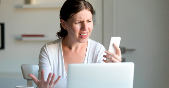 Woman looking at phone in disgust