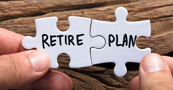 Two white puzzle pieces being pieced together with the words "retire" and "plan" written on them.