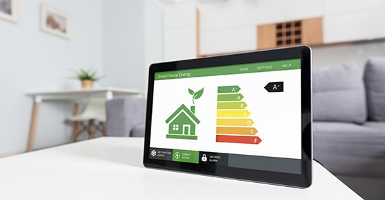 A tablet sitting up on a coffee table with a home energy efficiency tracking app open on the screen..