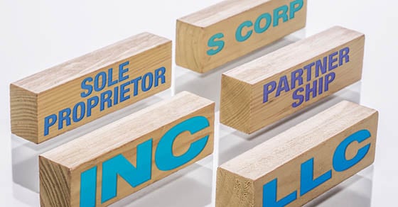 Five wooden blocks with different business entities written on them.