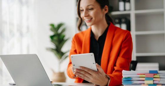 A woman sitting at a desk working on a laptop.