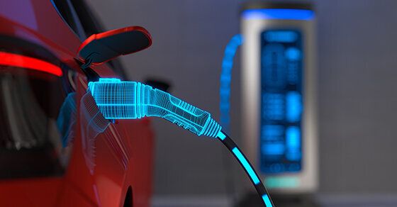 A red electric vehicle at a charging station. The charging cord has been edited so it looks like the electricity is visibly flowing through it.