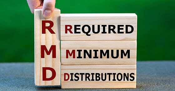 Stacked wooden blocks that read "RMD - Required Minimum Distributions".